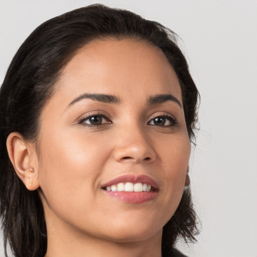 Joyful latino young-adult female with long  brown hair and brown eyes