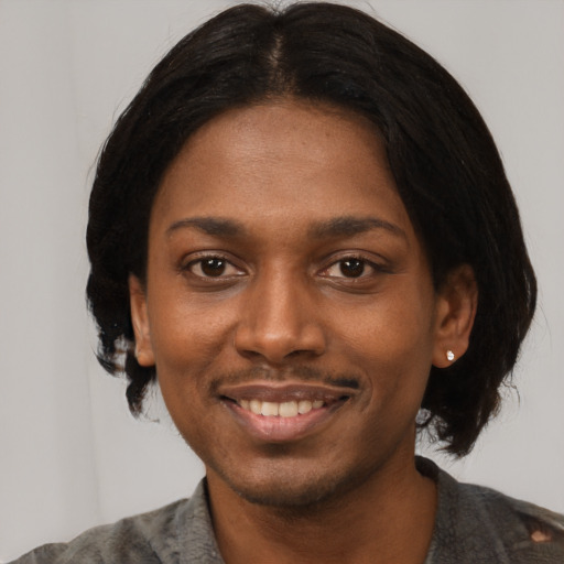 Joyful black young-adult female with short  black hair and brown eyes