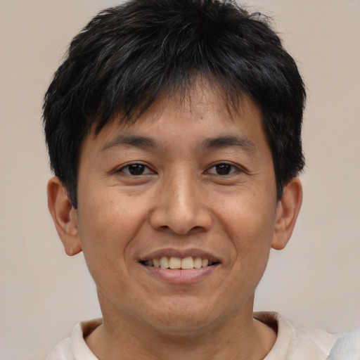 Joyful asian young-adult male with short  brown hair and brown eyes