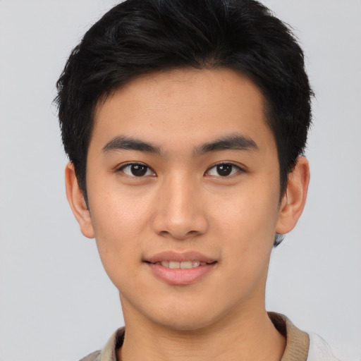 Joyful asian young-adult male with short  black hair and brown eyes