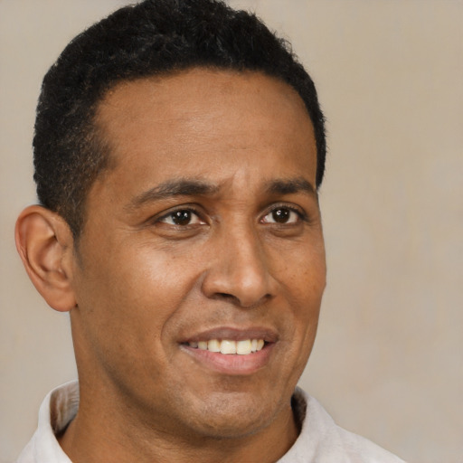 Joyful latino young-adult male with short  brown hair and brown eyes