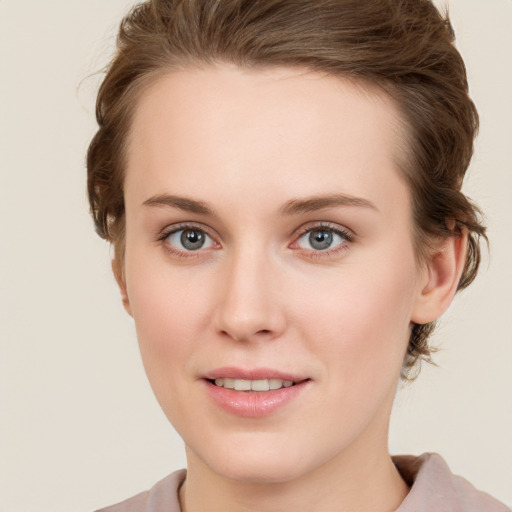 Joyful white young-adult female with short  brown hair and grey eyes