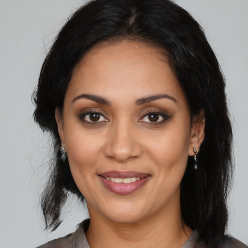 Joyful latino young-adult female with medium  black hair and brown eyes