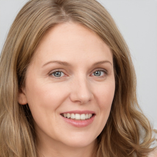 Joyful white young-adult female with long  brown hair and green eyes