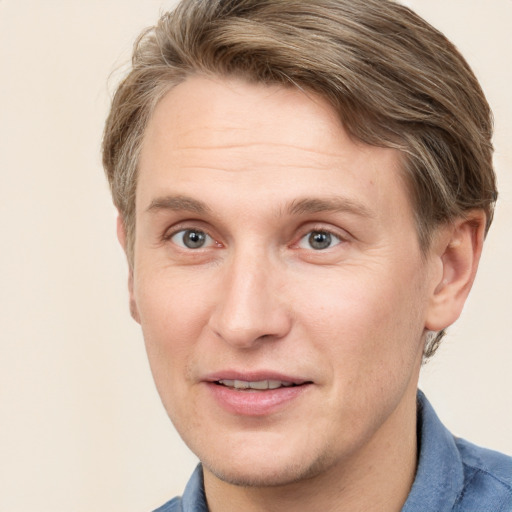 Joyful white adult male with short  brown hair and blue eyes