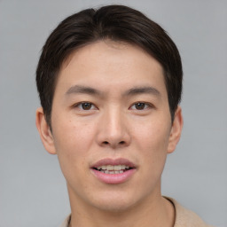 Joyful asian young-adult male with short  brown hair and brown eyes