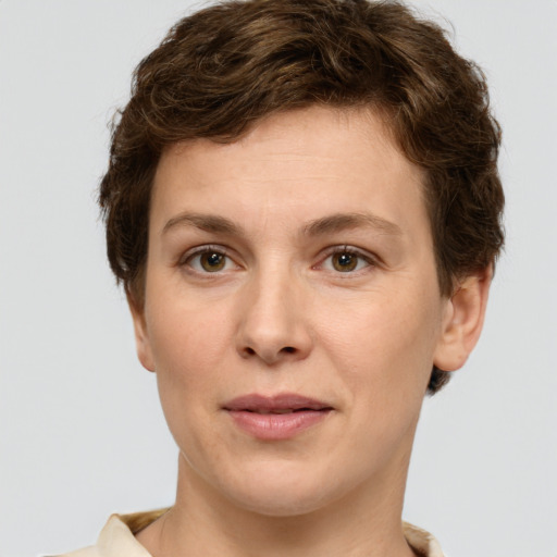 Joyful white young-adult female with short  brown hair and green eyes