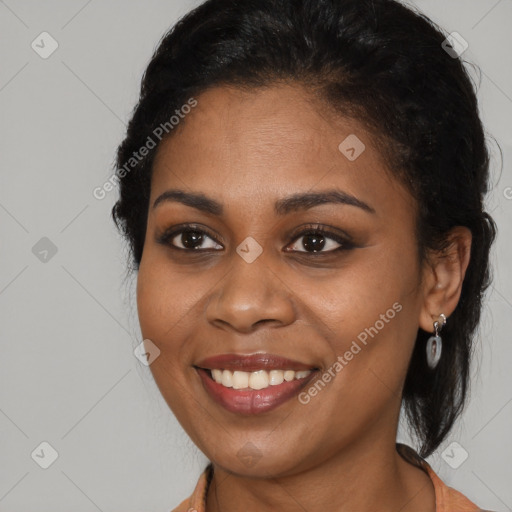 Joyful black young-adult female with long  brown hair and brown eyes