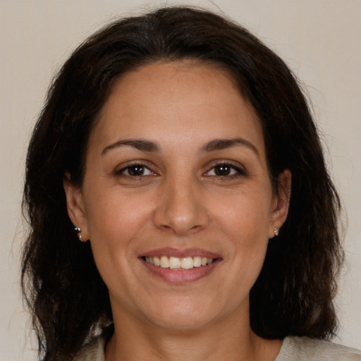 Joyful white adult female with medium  brown hair and brown eyes