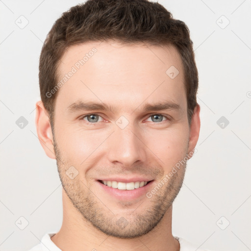 Joyful white young-adult male with short  brown hair and grey eyes