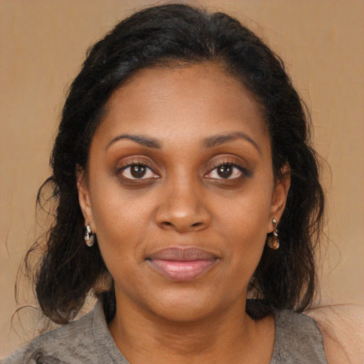 Joyful black young-adult female with medium  brown hair and brown eyes