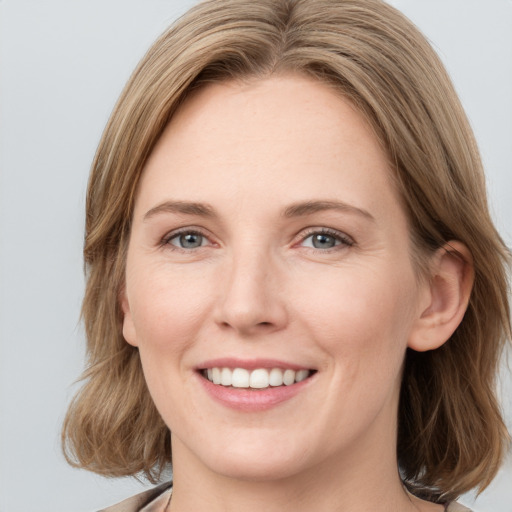 Joyful white young-adult female with medium  brown hair and blue eyes