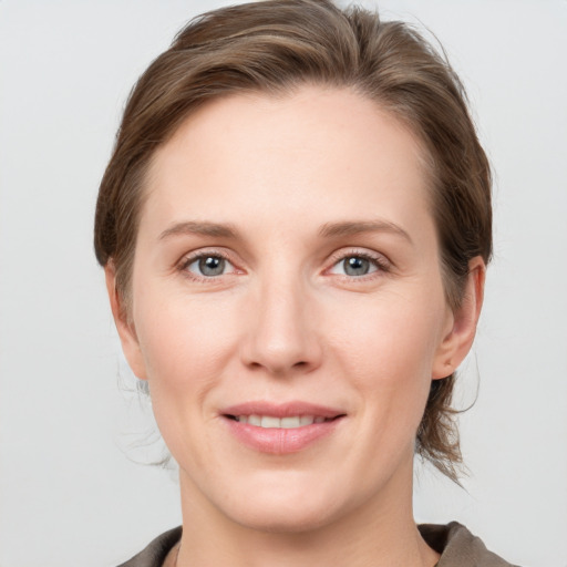 Joyful white young-adult female with medium  brown hair and grey eyes