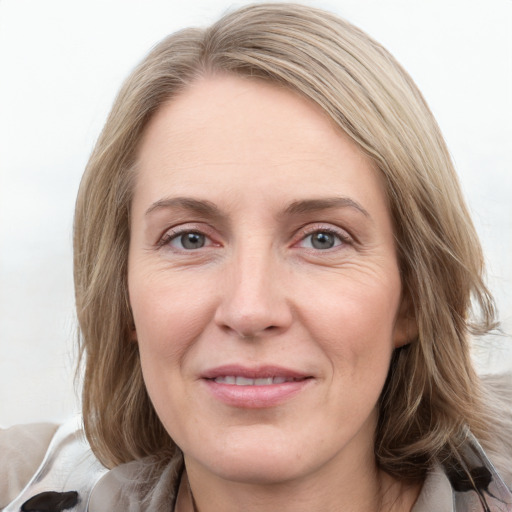 Joyful white adult female with medium  brown hair and grey eyes