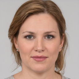 Joyful white young-adult female with medium  brown hair and grey eyes