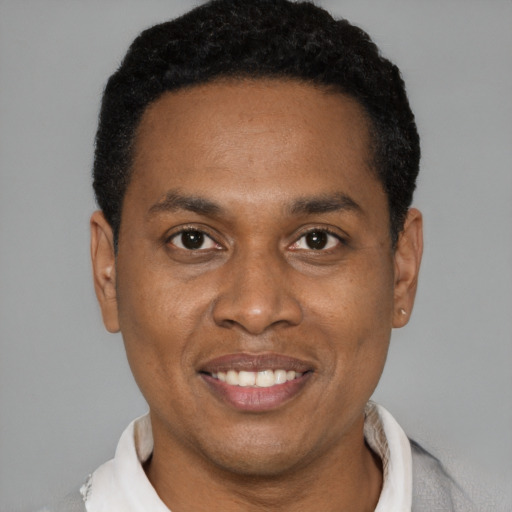 Joyful black young-adult male with short  black hair and brown eyes