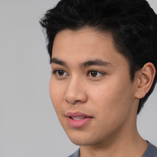 Joyful asian young-adult male with short  black hair and brown eyes