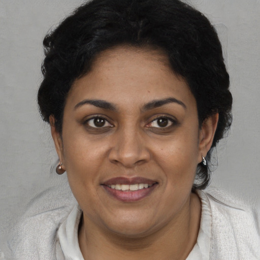 Joyful black adult female with short  brown hair and brown eyes