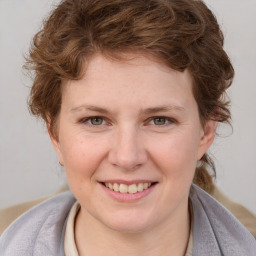 Joyful white young-adult female with medium  brown hair and blue eyes