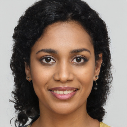 Joyful black young-adult female with long  brown hair and brown eyes