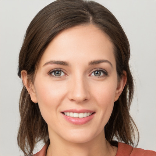 Joyful white young-adult female with medium  brown hair and grey eyes