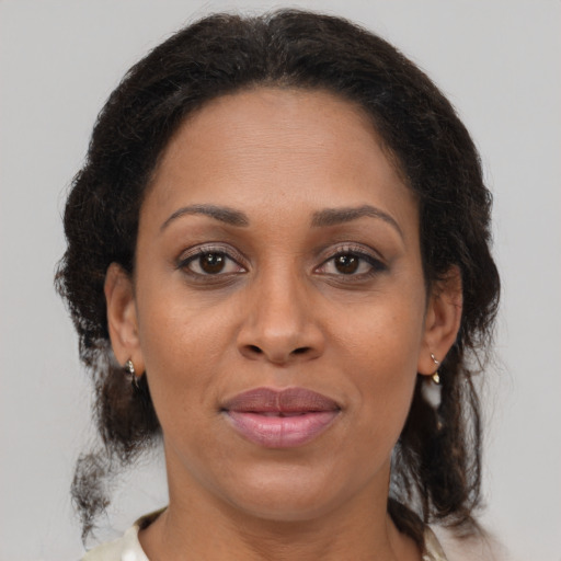 Joyful black adult female with medium  brown hair and brown eyes