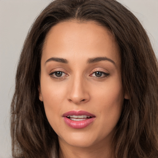 Joyful white young-adult female with long  brown hair and brown eyes