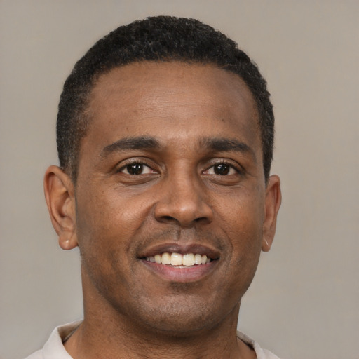 Joyful black young-adult male with short  brown hair and brown eyes