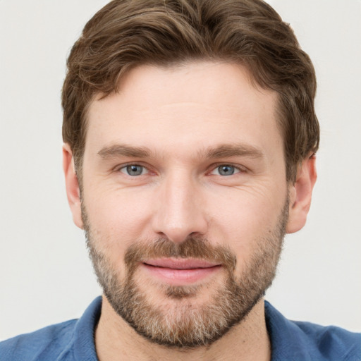 Joyful white young-adult male with short  brown hair and grey eyes