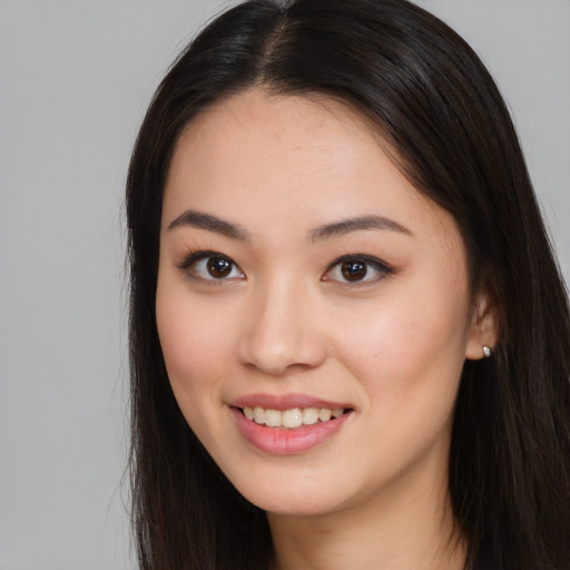 Joyful asian young-adult female with long  brown hair and brown eyes