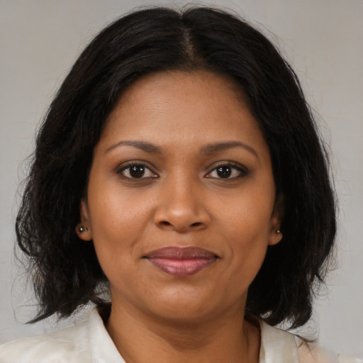 Joyful black adult female with medium  black hair and brown eyes