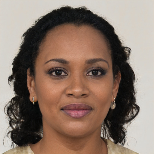 Joyful black young-adult female with long  brown hair and brown eyes
