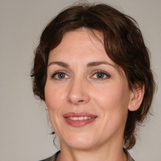 Joyful white adult female with medium  brown hair and green eyes