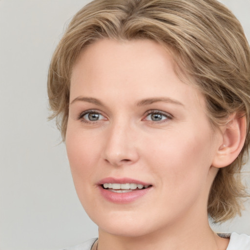 Joyful white young-adult female with medium  brown hair and blue eyes