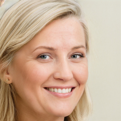 Joyful white adult female with long  blond hair and blue eyes