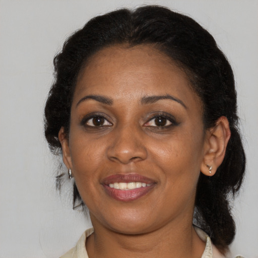 Joyful black adult female with long  brown hair and brown eyes