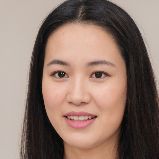 Joyful asian young-adult female with long  brown hair and brown eyes