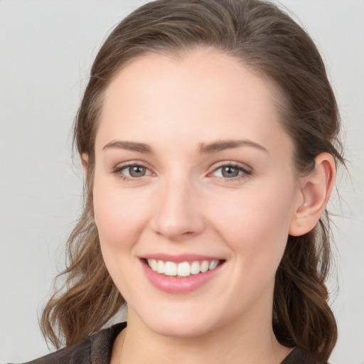 Joyful white young-adult female with long  brown hair and grey eyes