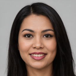 Joyful latino young-adult female with long  brown hair and brown eyes