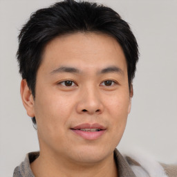 Joyful asian young-adult male with short  brown hair and brown eyes