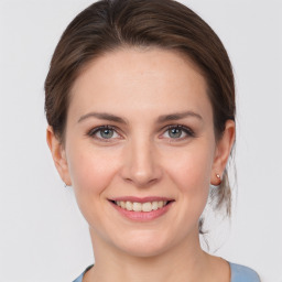 Joyful white young-adult female with medium  brown hair and grey eyes