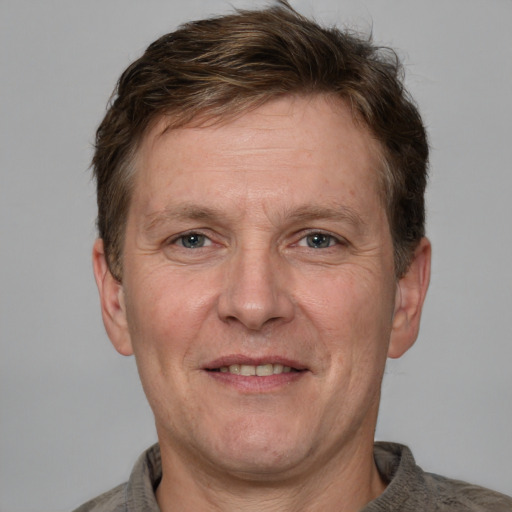 Joyful white adult male with short  brown hair and grey eyes