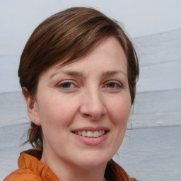 Joyful white young-adult female with medium  brown hair and blue eyes