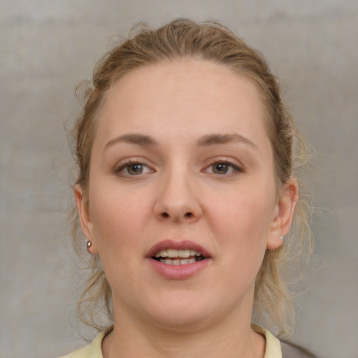 Joyful white young-adult female with medium  brown hair and grey eyes