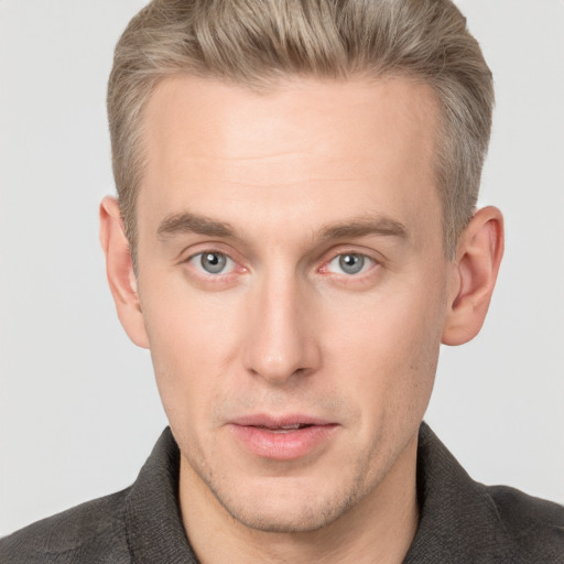 Joyful white adult male with short  brown hair and blue eyes