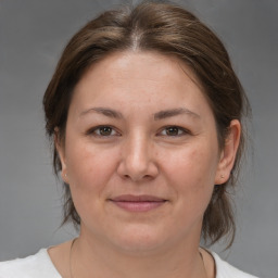 Joyful white adult female with medium  brown hair and brown eyes