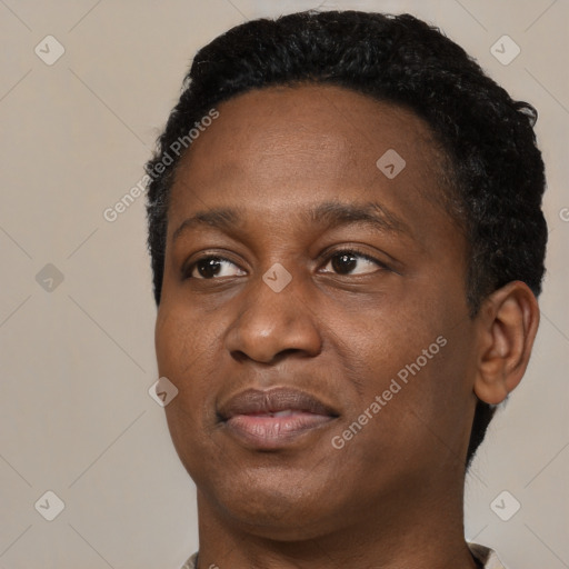 Joyful black young-adult male with short  brown hair and brown eyes