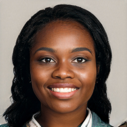 Joyful black young-adult female with long  black hair and brown eyes