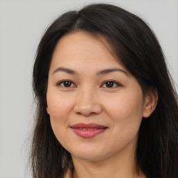 Joyful asian young-adult female with long  brown hair and brown eyes