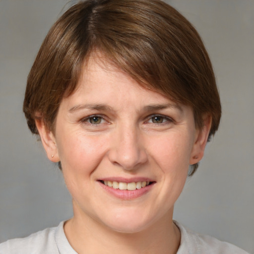 Joyful white young-adult female with short  brown hair and grey eyes